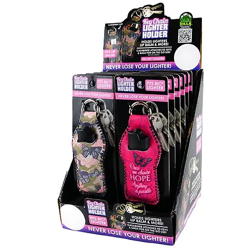 Display box filled with keychain lighter holders. Each holder is individually packaged and designed to fit BIC lighters. The holders come in various designs, including a camouflage pattern and a pink design with a ribbon symbol. The packaging includes text such as “NEVER LOSE YOUR LIGHTER!” and “Once chosen HOPE is possible.” The display box is black with bold white text emphasizing not losing your lighter.